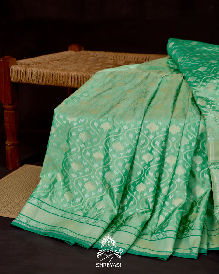 Banarasi Ektara silk saree in soft green with jamdani-style cutwork motifs and subtle woven border