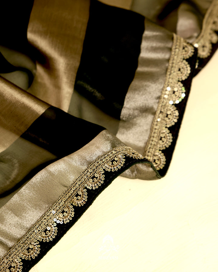 Organza silk saree with broad woven zari stripes, scalloped edges, ornate metallic borders, and a coordinating blouse