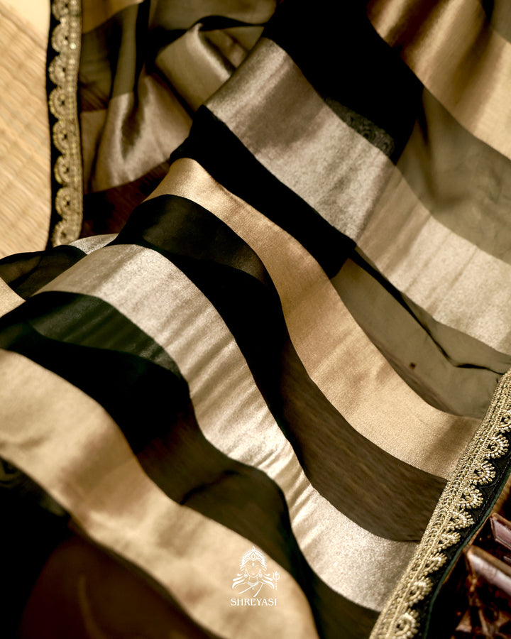Organza silk saree with broad woven zari stripes, scalloped edges, ornate metallic borders, and a coordinating blouse
