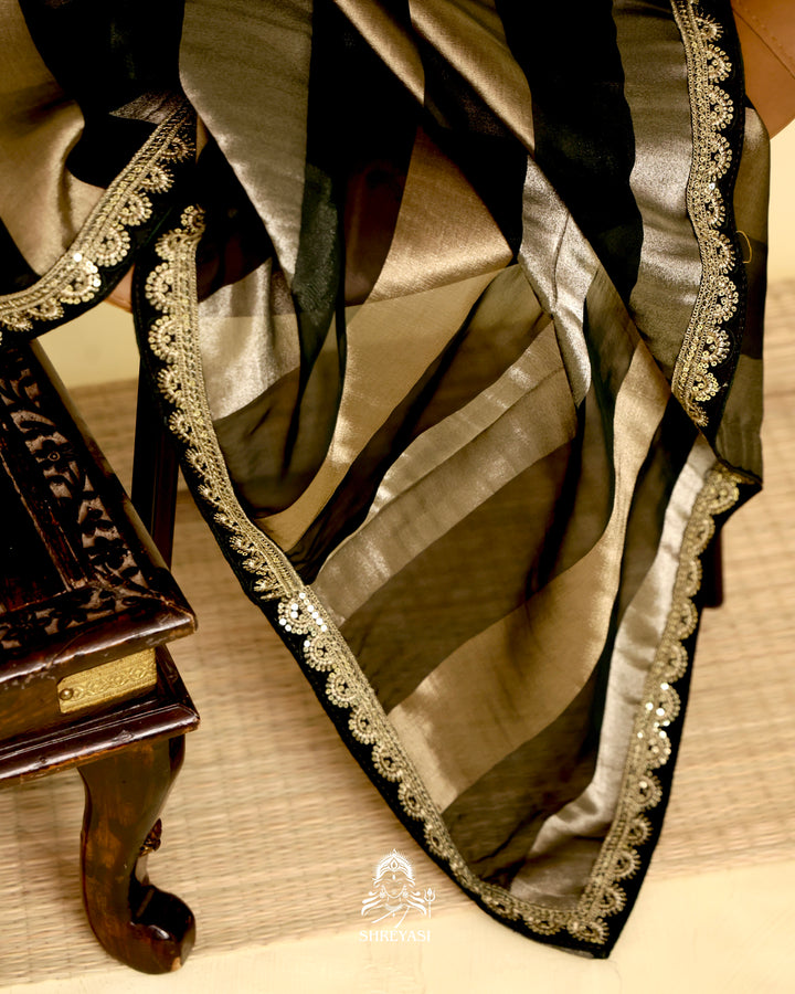 Organza silk saree with broad woven zari stripes, scalloped edges, ornate metallic borders, and a coordinating blouse