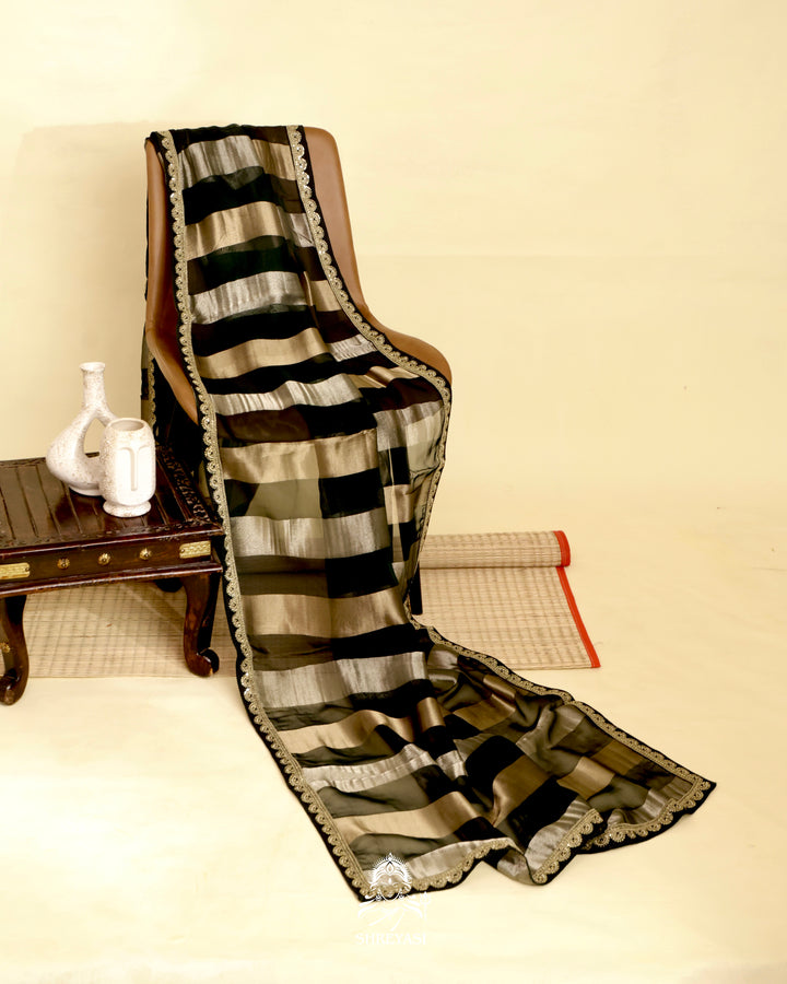 Organza silk saree with broad woven zari stripes, scalloped edges, ornate metallic borders, and a coordinating blouse