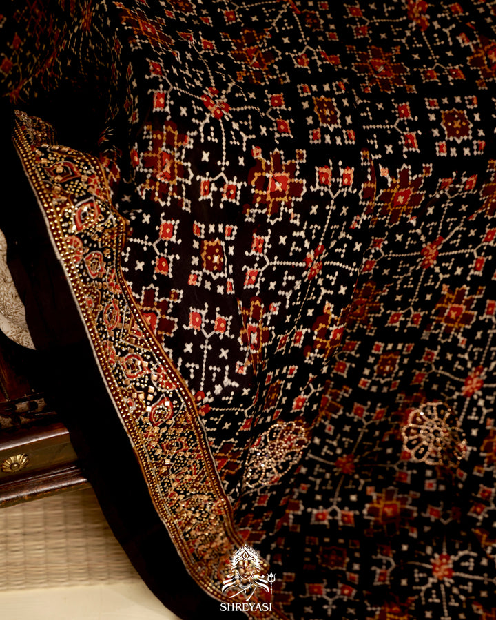 Ajrakh modal silk saree with traditional geometric prints and subtle Swarovski bead embellishment on a black base